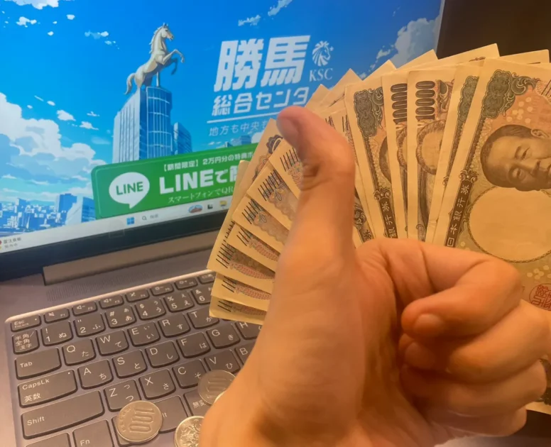 勝馬総合センターの画面の前で、無料予想の的中金額である78,400円の札束を広げて持っている手元の様子