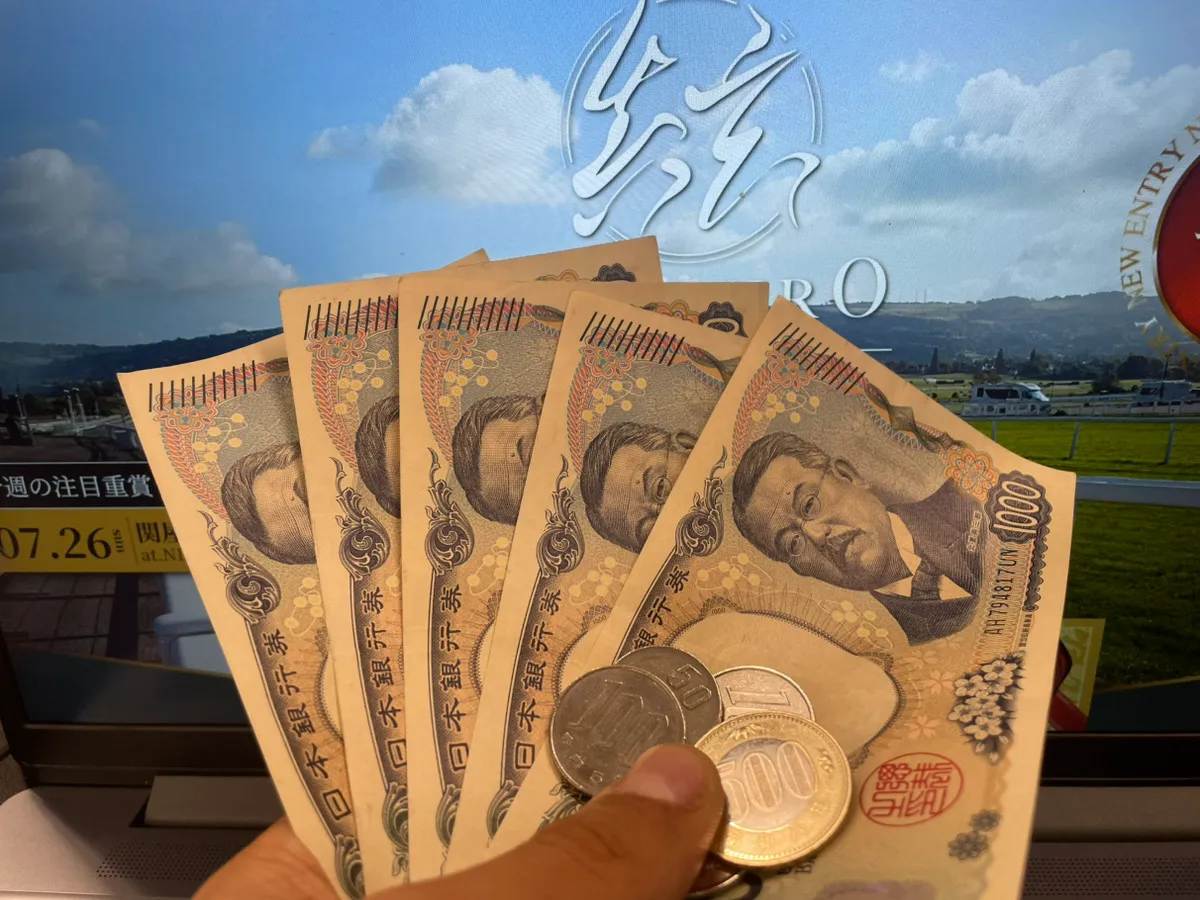 シンクロの画面の前で、無料予想の的中金額である5,850円の払い戻し画面を提示している様子