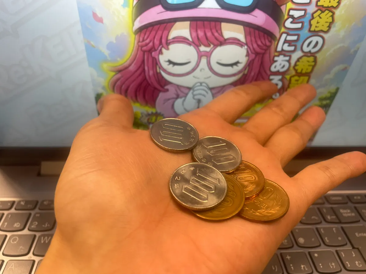 Re:keiba（リケイバ）の画面の前で、無料予想の的中金額である330円を広げて持っている手元の様子
